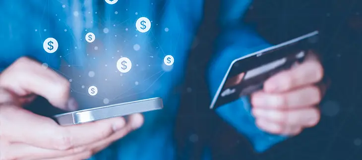 Man using his cell phone with his right hand while holding a bank card in his left hand