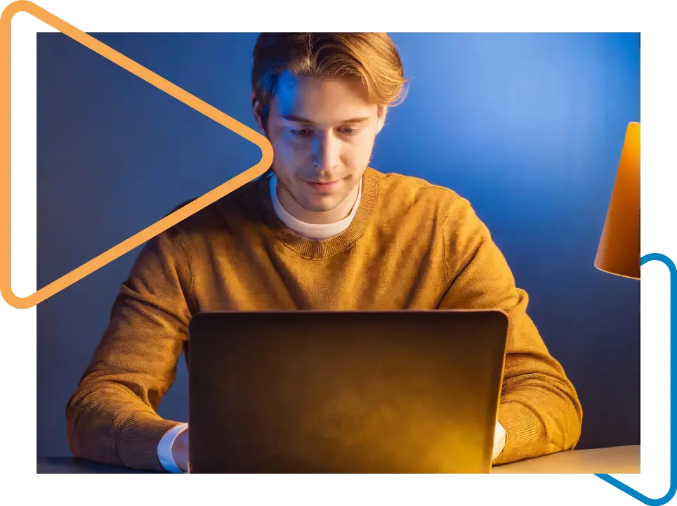 Homem branco de camiseta amarela mexendo no notebook